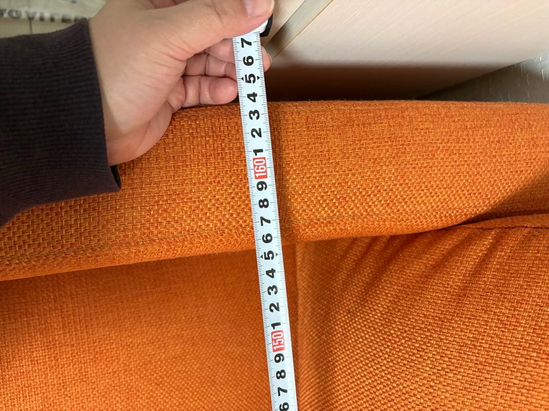オレンジ色の3人掛けソファ