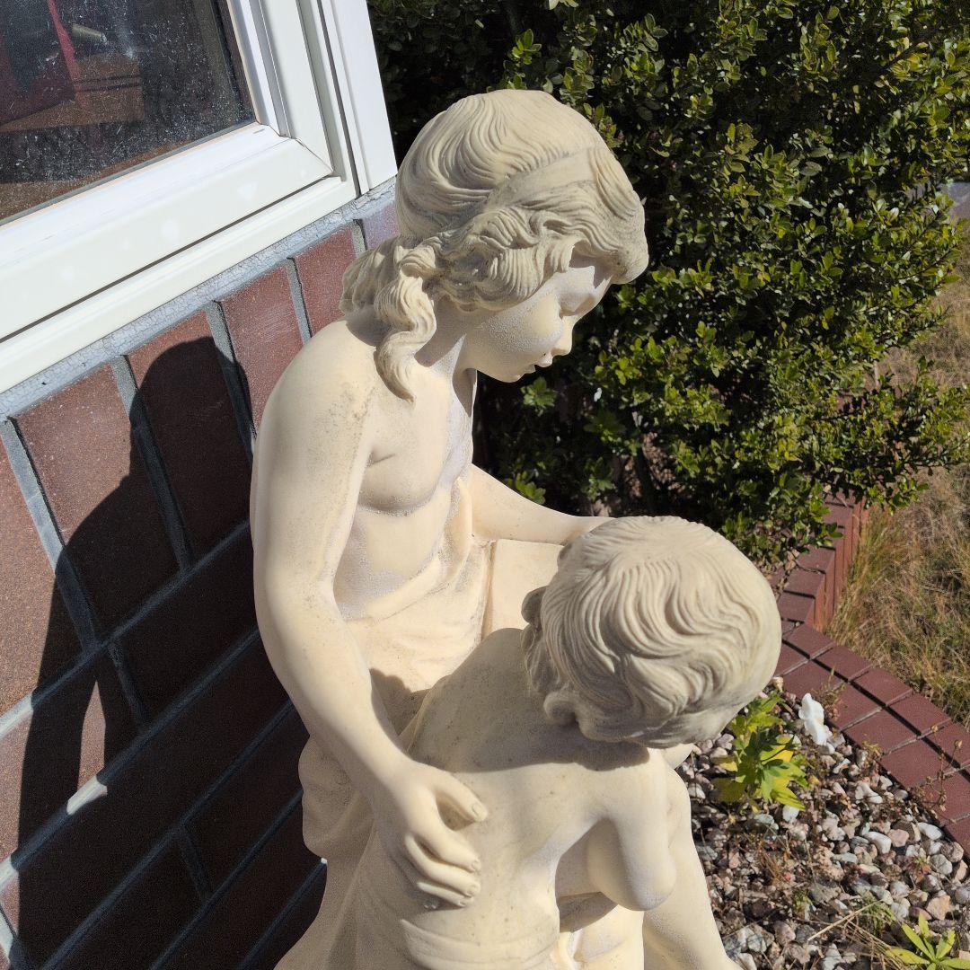 子供と本を読む少女の彫刻